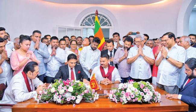 එළ­ඹෙන ජනා­ධි­ප­ති­ව­ර­ණ­යට ශ්‍රී ලංකා පොදු­ ජන පෙර­මු­ණෙන් ඉදි­රි­ප­ත්වීම සඳහා එම පක්ෂයේ ජාතික සංවි­ධා­යක, පාර්ලි­මේන්තු මන්ත්‍රී නාමල් රාජ­පක්ෂ මහතා කොළඹ විජේ­රාමේ පිහිටි හිටපු ජනා­ධි­පති මහින්ද රාජ­පක්ෂ මහ­තාගේ නිවෙ­සේදී නාමයෝජනා පත්‍ර­යට ඊයේ (14) අත්සන් තැබීය. එම අව­ස්ථා­වට හිටපු ජනා­ධි­ප­ති­ව­රුන් වන මහින්ද රාජ­පක්ෂ, ගෝඨා­භය රාජ­පක්ෂ, හිටපු ඇමැති බැසිල් රාජ­පක්ෂ, පක්ෂයේ මහලේකම්, පාර්ලි­මේන්තු මන්ත්‍රී සාගර කාරි­ය­ව­සම් මහ­ත්ව­රුන් ඇතුළු මන්ත්‍රී­වරු පිරි­සක් එක්ව සිටි අයුරු.